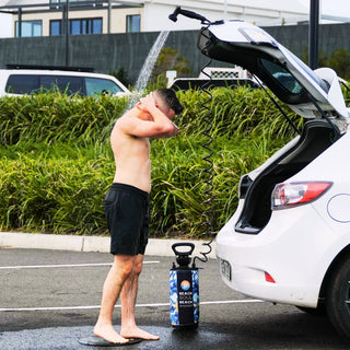 Beach Soul portable camping shower used for an outdoor rinse behind a vehicle