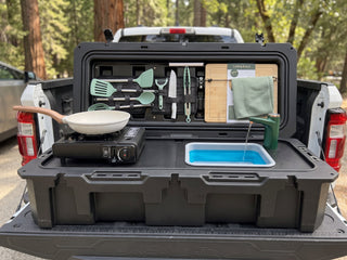 VOZ portable camp kitchen on a pickup truck tailgate with cooking station and running water faucet