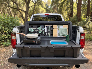 VOZ portable camp kitchen front view on a pickup truck tailgate with cooking station, sink and rechargeable faucet